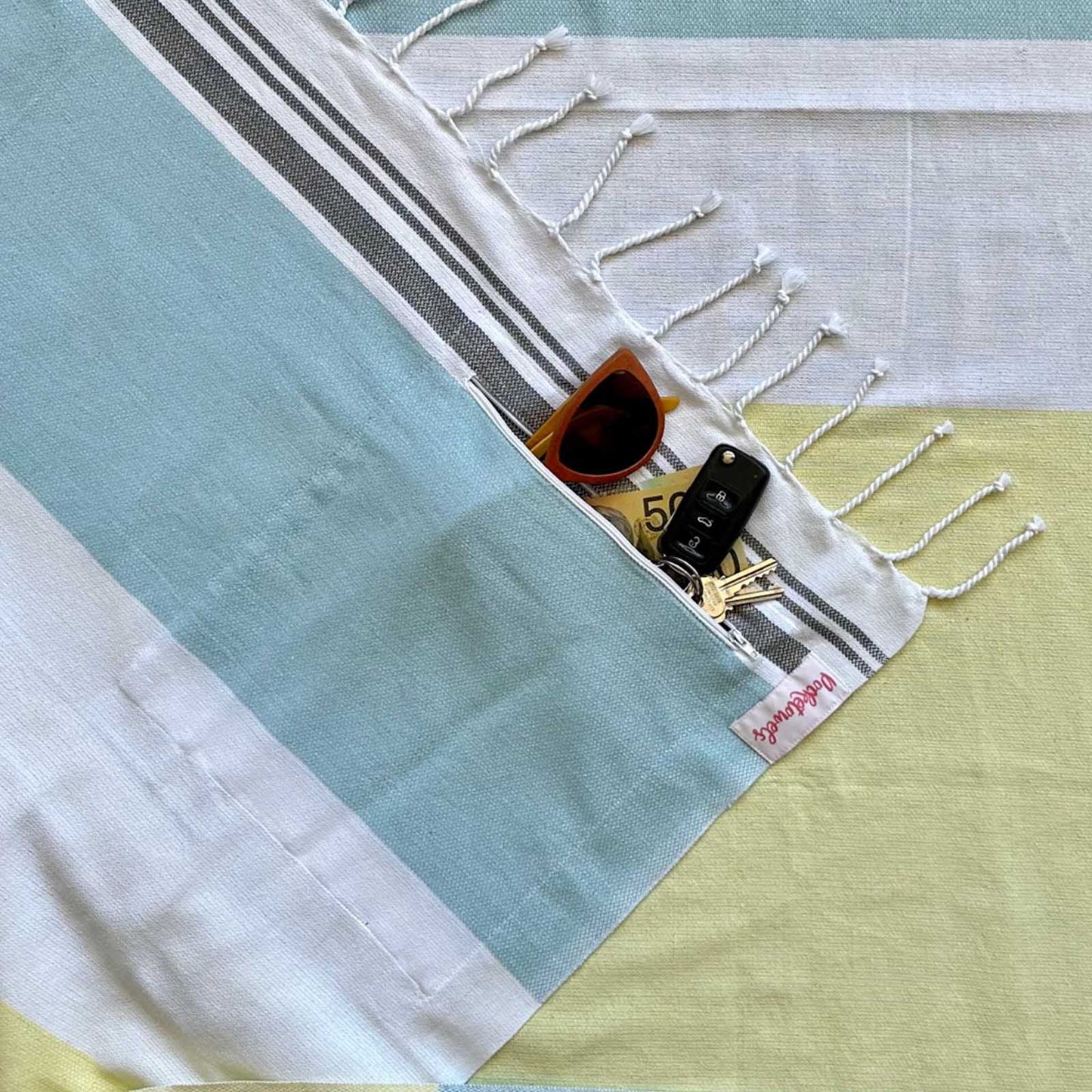Agatti is a pastel blue and lemon Pocketowel folded - this is a large beach towel with pocket, by Freostyle