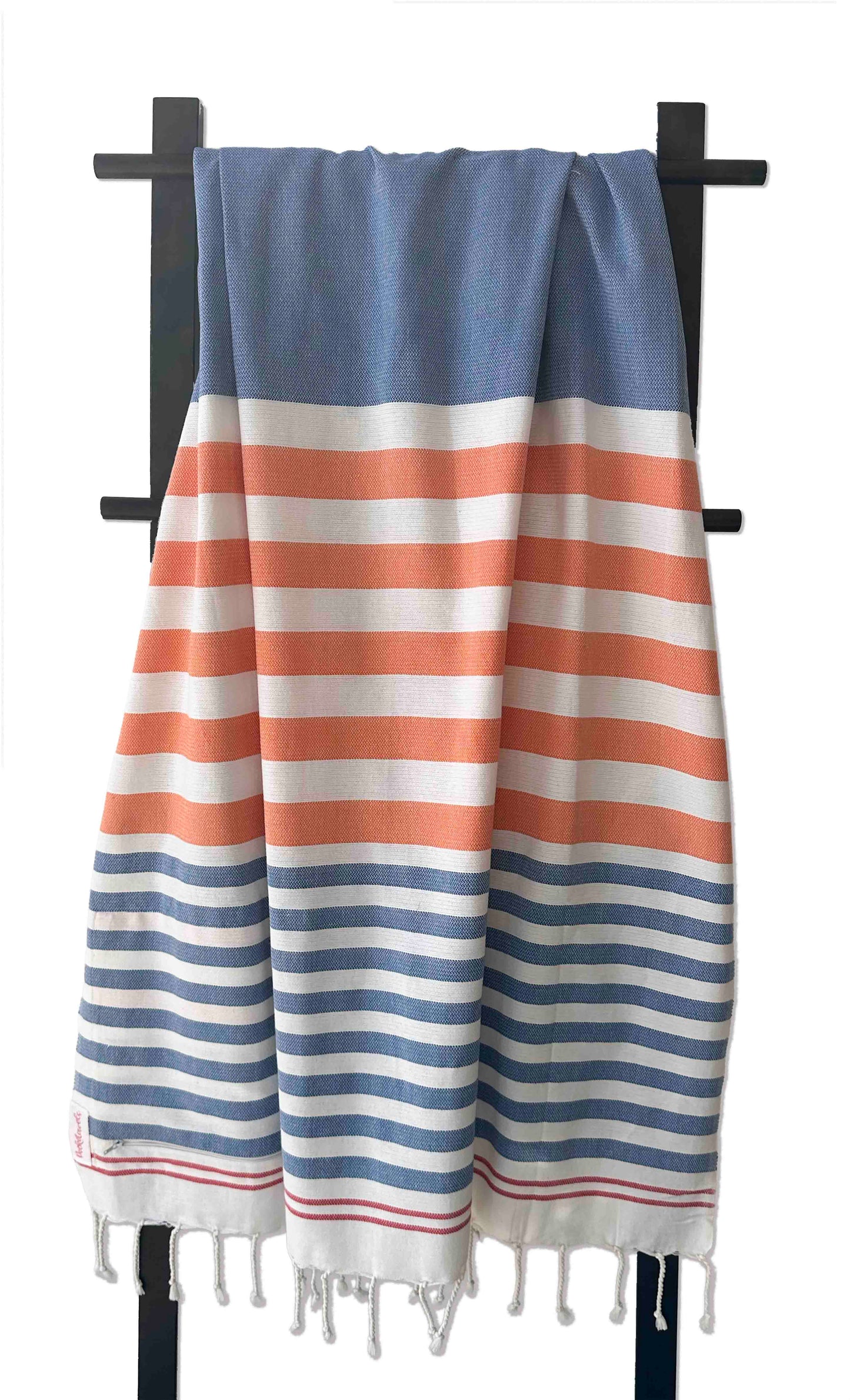 Striped towel with blue, orange, and white colors on a black rack. Pocketowels by Freostyle