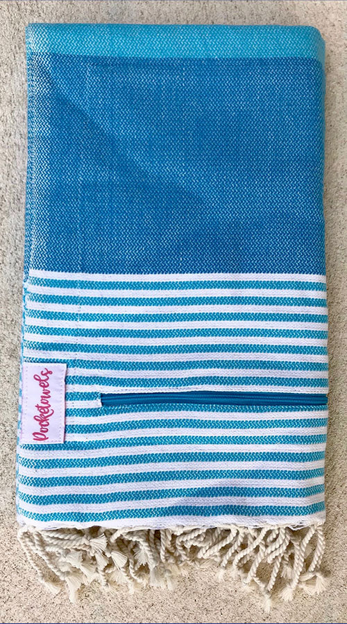 Andaman Pocketowel features sky-blue, turquoise and white stripe for a cool coastal vibe. Pocketowels are large beach towels with pockets